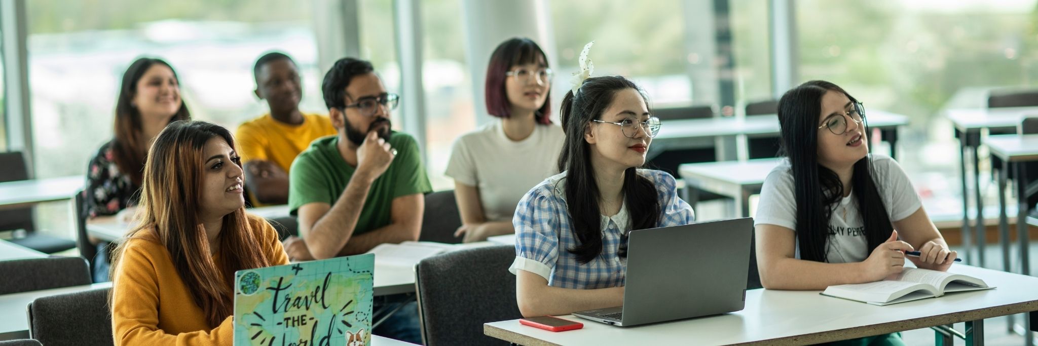 Students sat in a classroom looking up listening to the lecturer