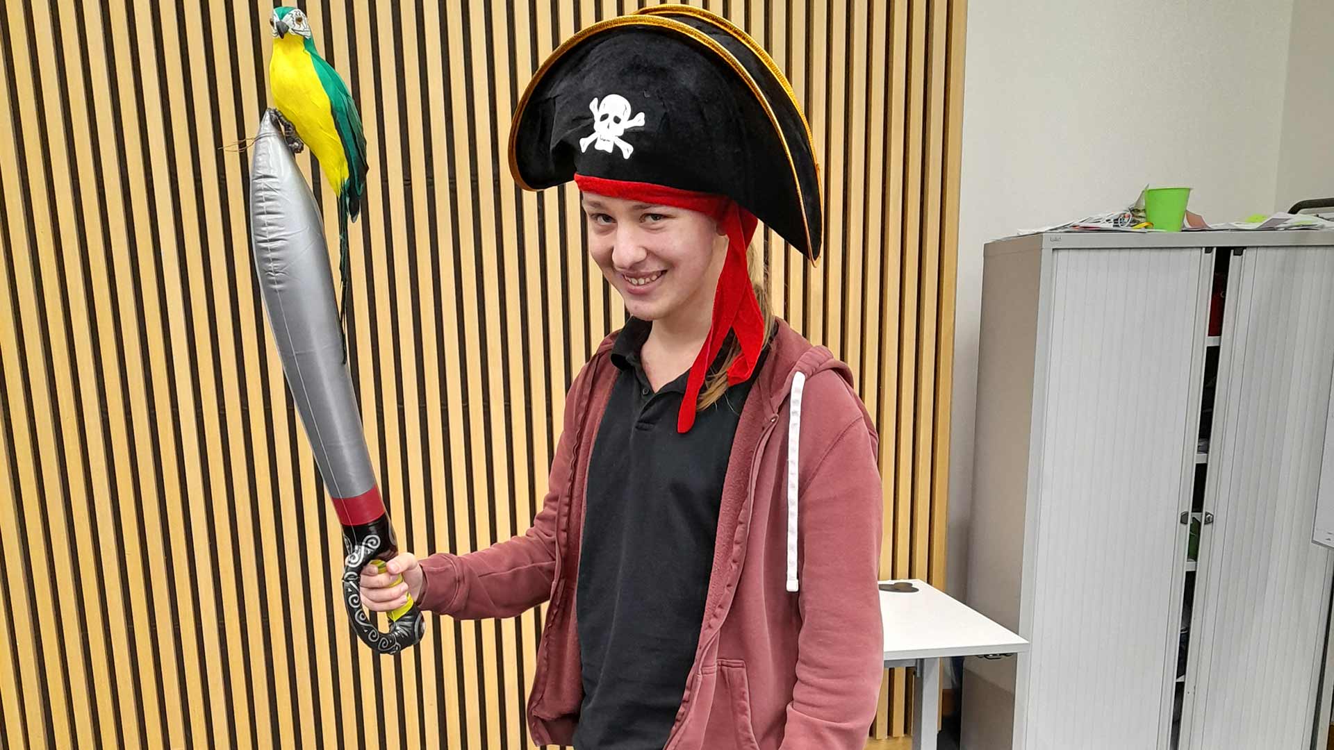 Nathan wearing a pirate hat and holding an inflatable sword during a University event.