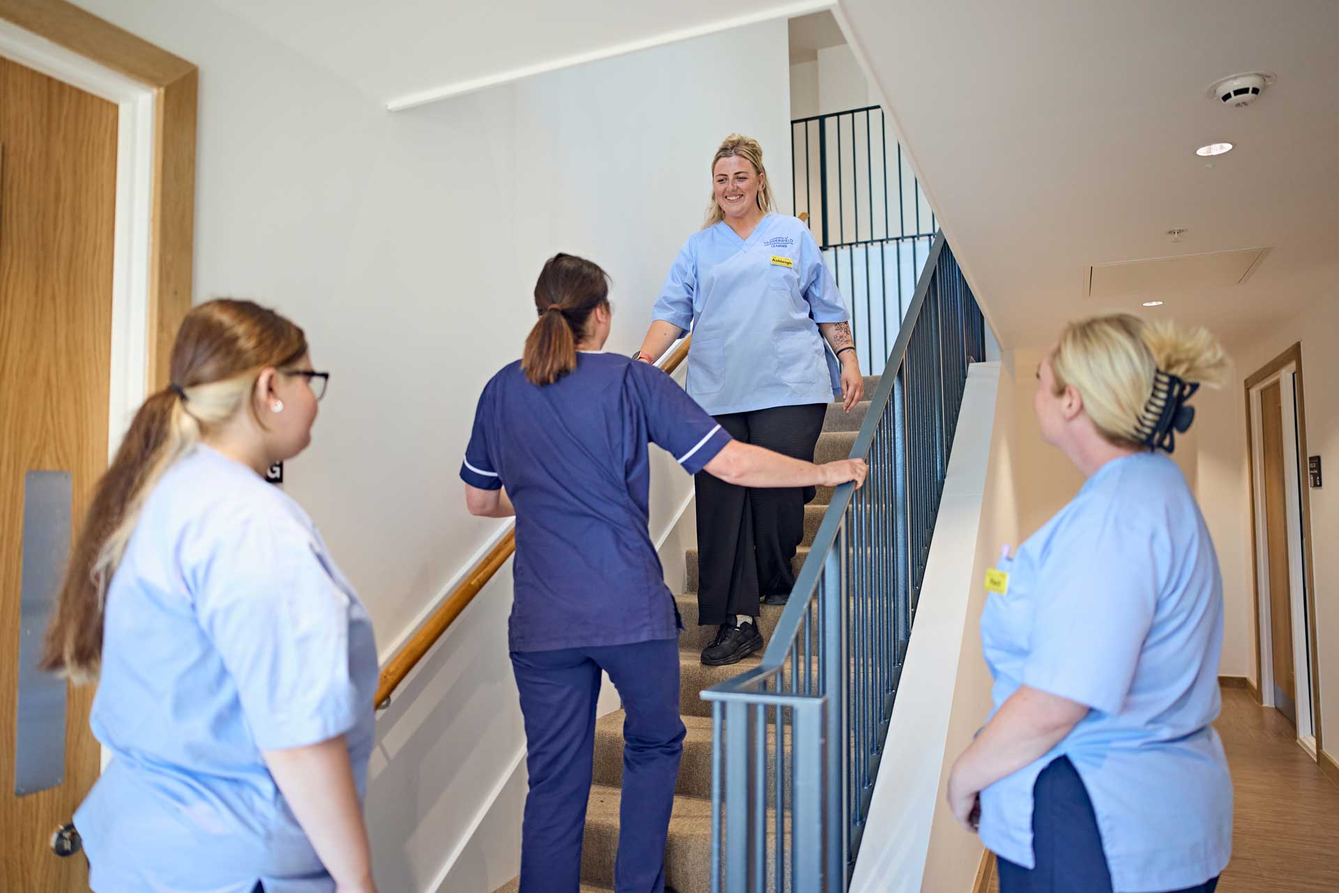 An occupational therapist demonstrates safe stair transfers to a student, preparing them for real-world practice.